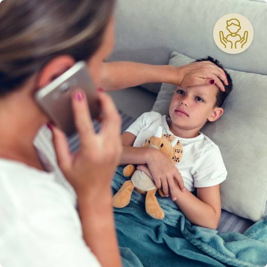 Mutter telefoniert während sie bei Ihrem kranken Sohn die Stirn fühlt
